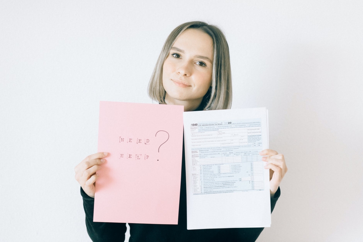 woman holding a pink paper offering service on tax forms